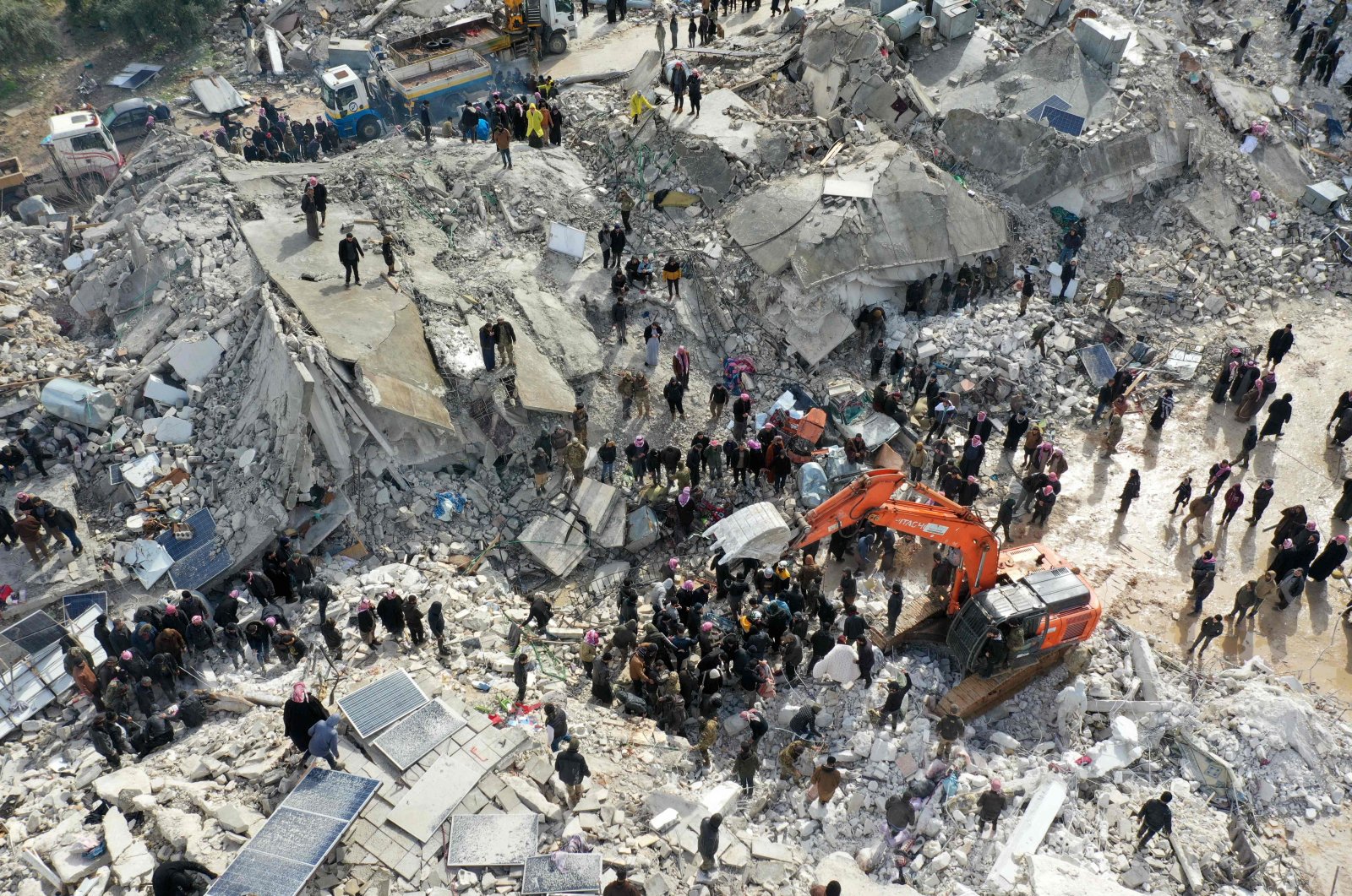 This aerial view shows residents, aided by heavy equipment, searching for victims and survivors amidst the rubble of collapsed buildings following an earthquake in the village of Besnia near the town of Harim, in Syria&#039;s opposition-held northwestern Idlib on the border with Türkiye, Feb. 6, 2022. (AFP Photo)
