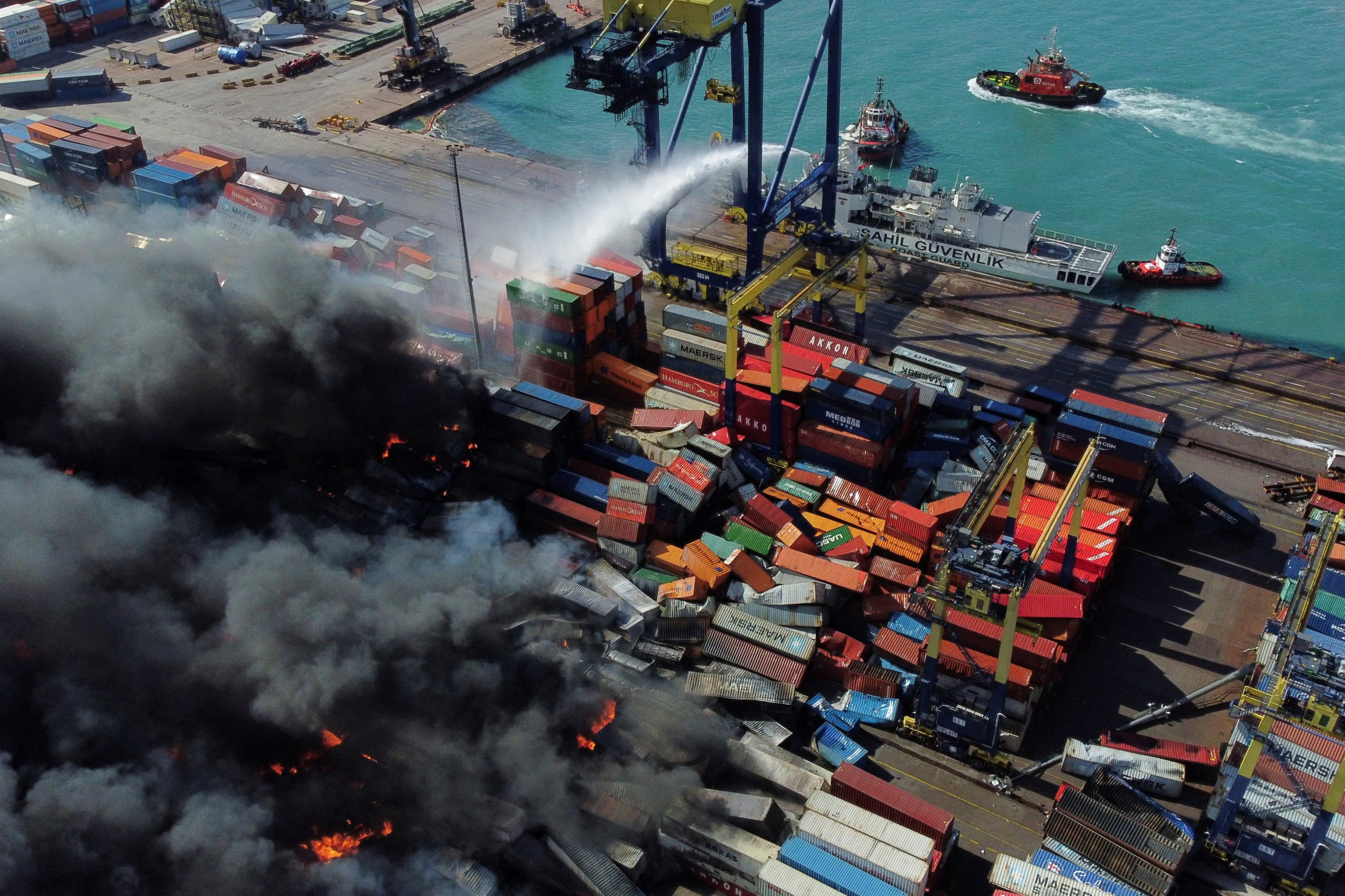 Asap mengepul dari kontainer yang terbakar di pelabuhan di kota Iskenderun yang dilanda gempa, Hatay, Türkiye, 7 Februari 2023. (Foto Reuters)