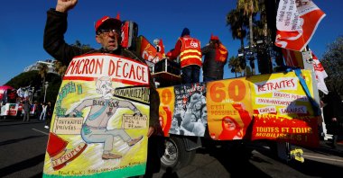 A CGT labor union member with a placard that reads "Macron Get Out" attends a demonstration against the French government's pension reform plan in Nice as part of the third day of national strike and protests in France, Feb. 7, 2023. (Reuters Photo)