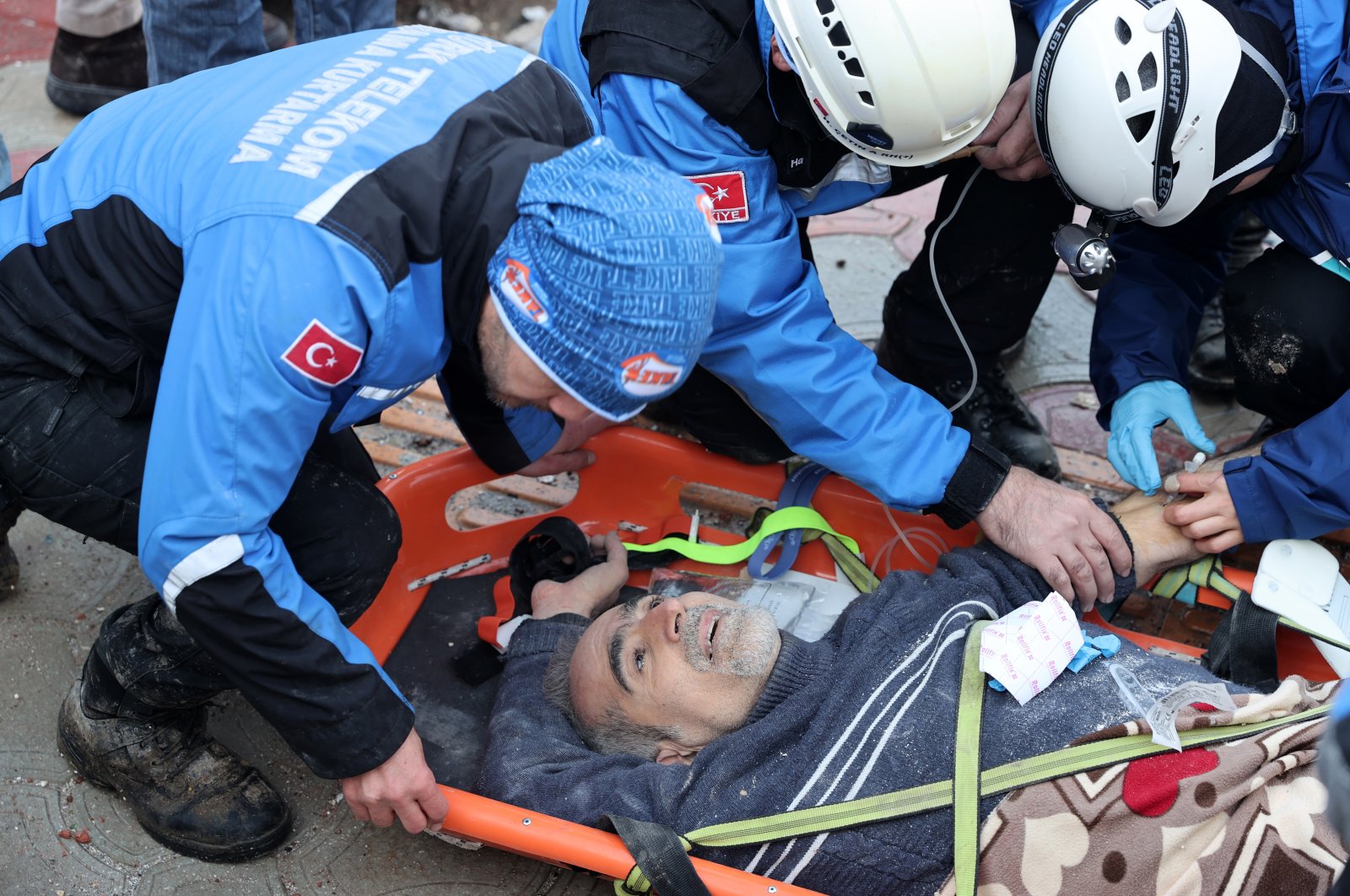 Survivor Ferit Güzeloğlu is strapped to a stretcher after being rescued from the wreckage in Hatay following the two deadly earthquakes that struck 10 cities in Türkiye&#039;s southeastern region on Tuesday, Feb. 7, 2023. (AA Photo)