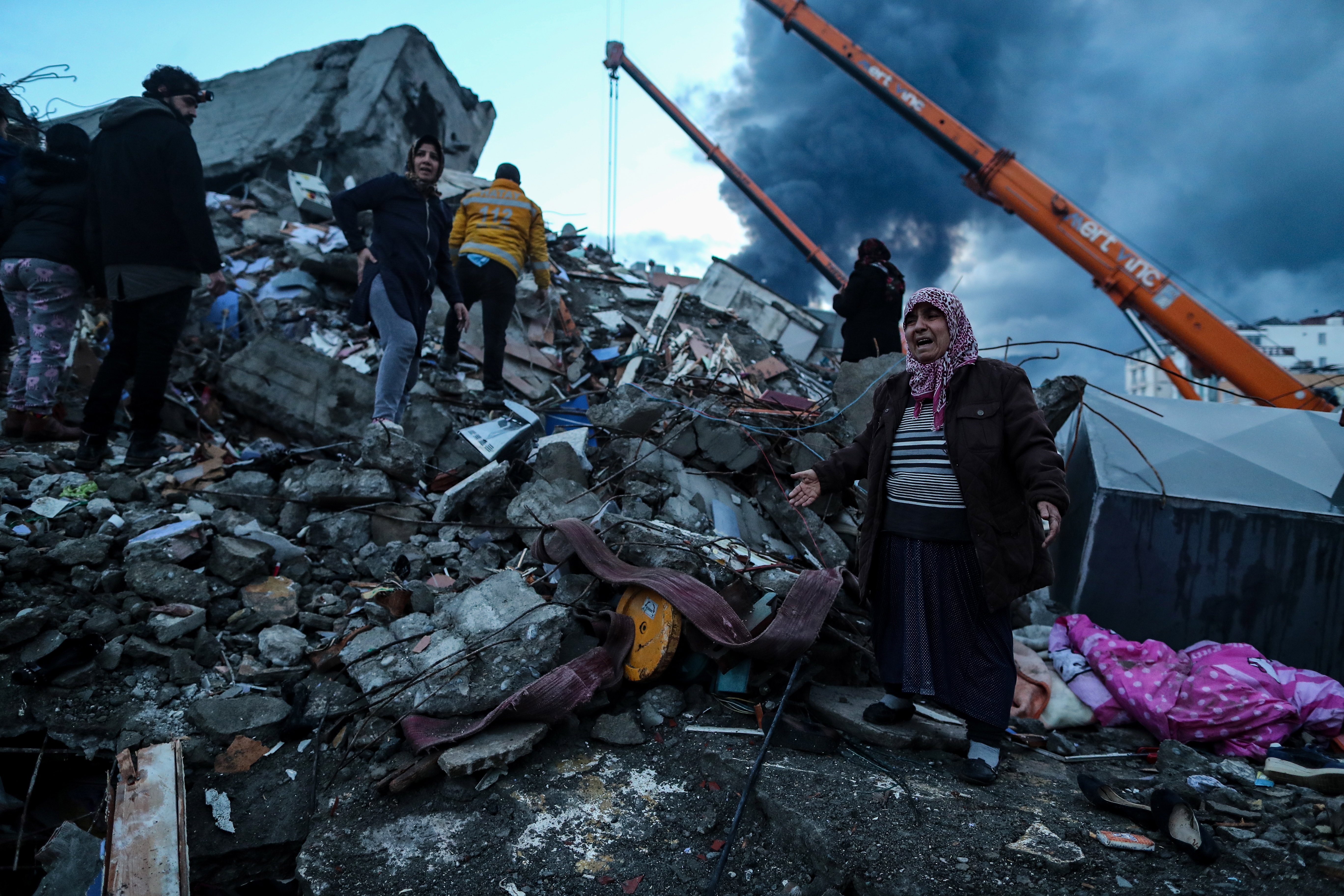 A woman reacts as emergency personnel carry out a search and rescue operation at the site of a collapsed building following an earthquake in Iskenderun, district of Hatay, Türkiye, Feb. 7, 2023. (EPA Photo)