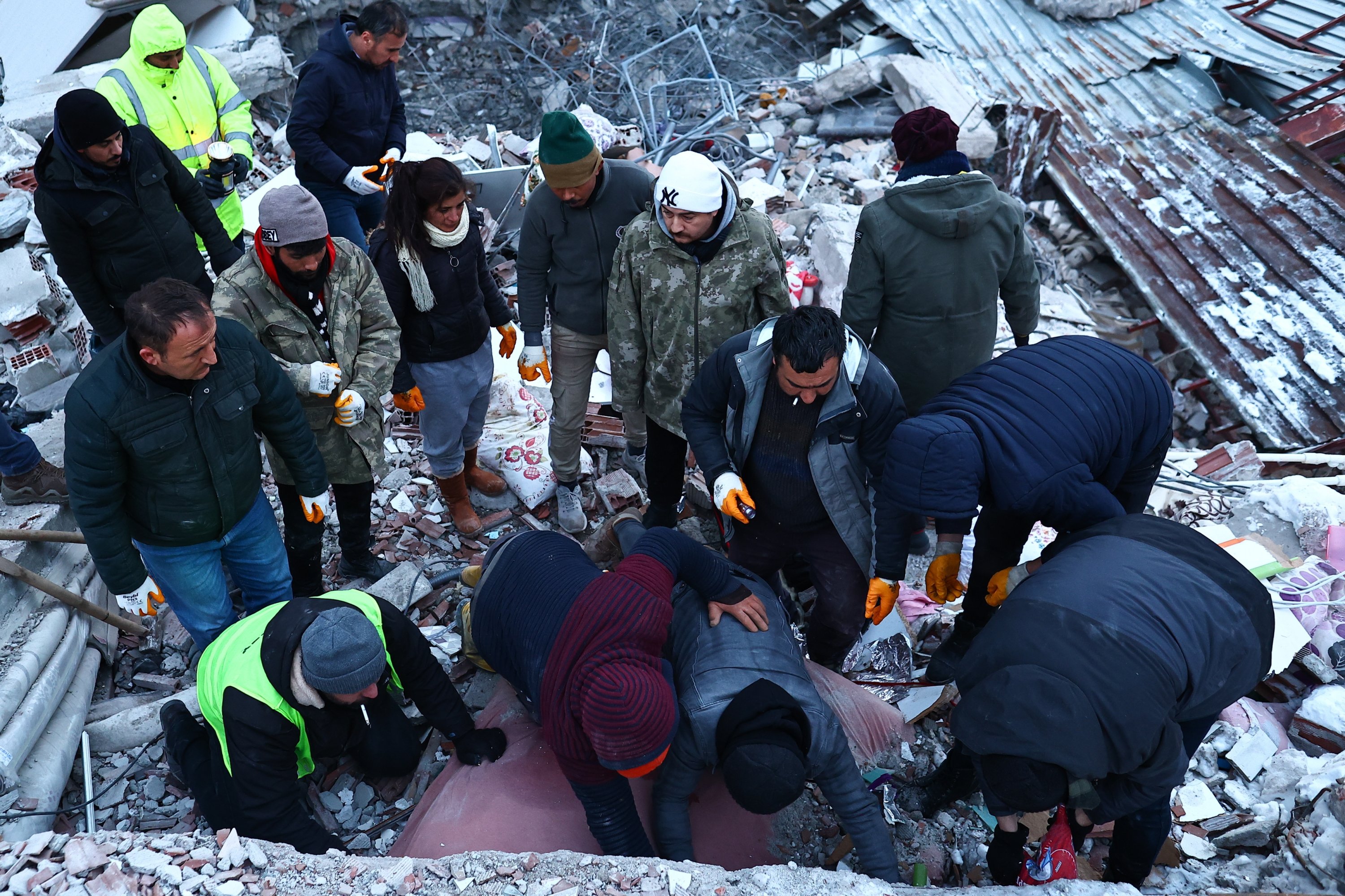 Petugas darurat dan penduduk setempat mencari korban selamat di lokasi bangunan yang runtuh setelah gempa besar di distrik Elbistan, Kahramanmaras, Türkiye, 8 Februari 2023. (Foto EPA)