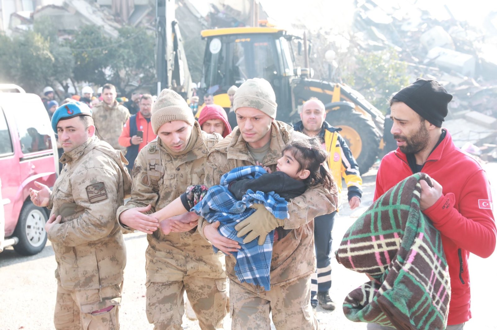 Soldiers of Turkish Armed Forces carries a child rescued from the debris of quake zone, Feb. 8, 2023. (DHA Photo)