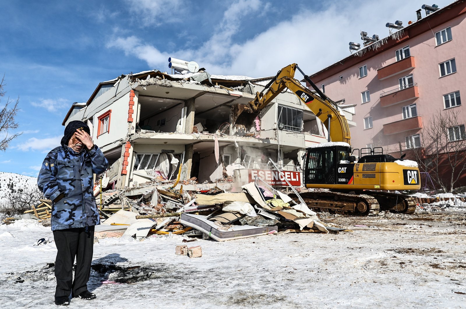 A woman reacts next to a collapsed building during search operations in the aftermath of a powerful earthquake in the Elbistan district of Kahramanmaraş, southeastern Türkiye, Feb. 7, 2023. (EPA Photo)