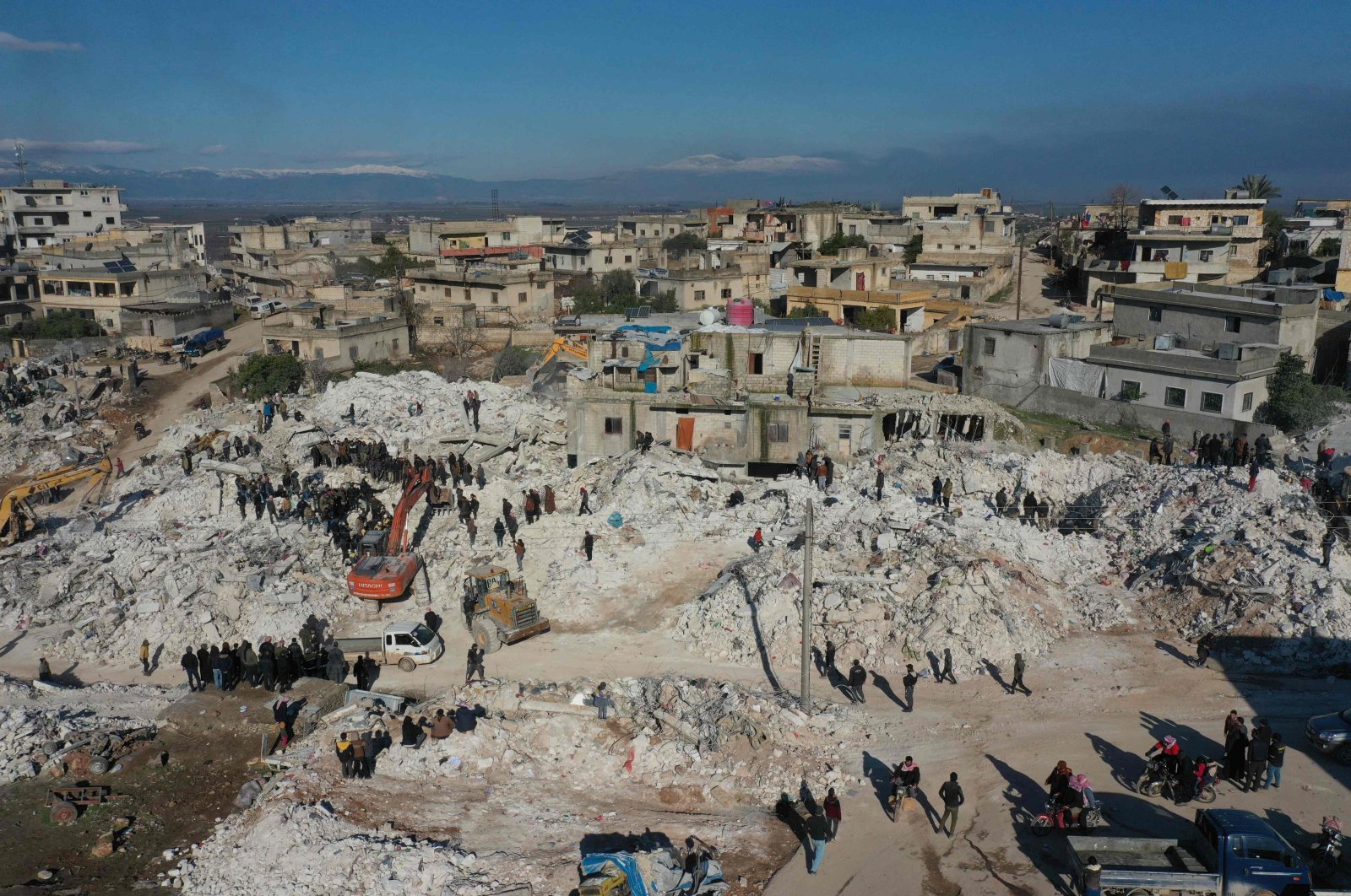 This aerial view shows rescuers searching for survivors amidst the rubble of a collapsed building in the town of Harim in Syria&#039;s opposition-held northwestern Idlib province on the border with Türkiye, on Feb. 8, 2023. (AFP Photo)