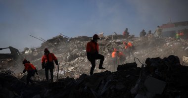Rescuers walk over the rubble in the aftermath of a deadly earthquake in Kahramanmaraş, Türkiye, Feb. 9, 2023. (Reuters Photo)