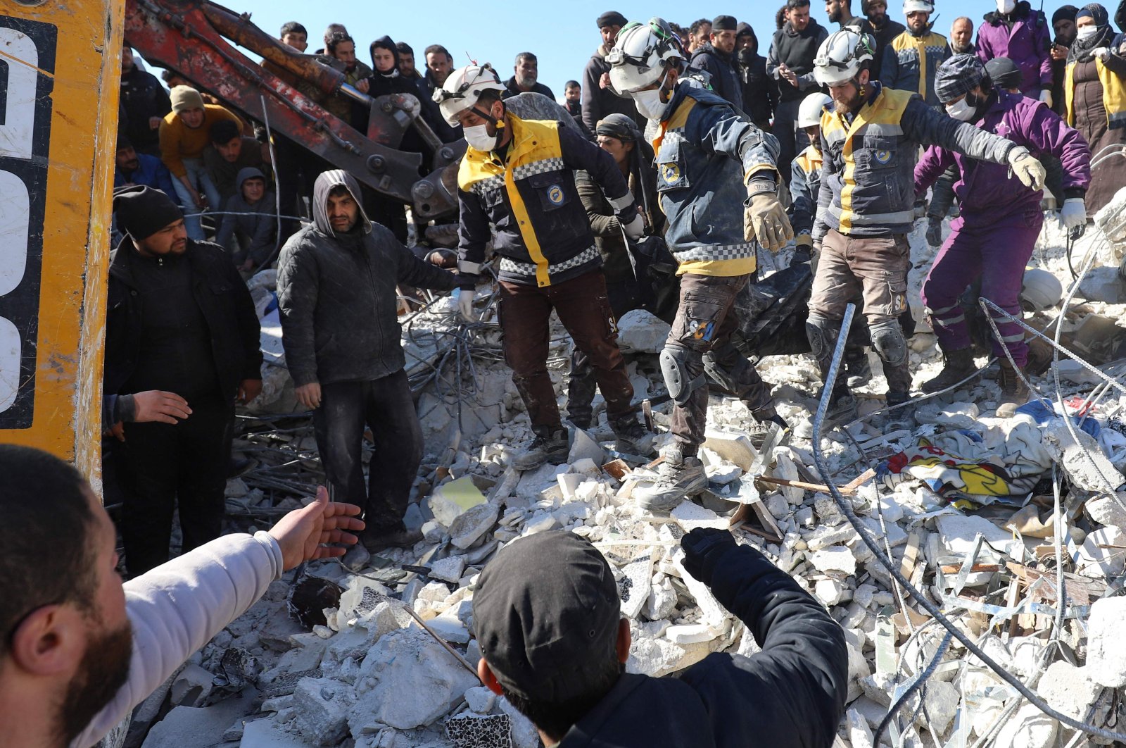 Syrian White Helmet rescuers and residents recover a body from the rubble of a destroyed building in the village of Azmarin, Idlib, northwestern Syria, Feb. 8, 2023. (AFP Photo)