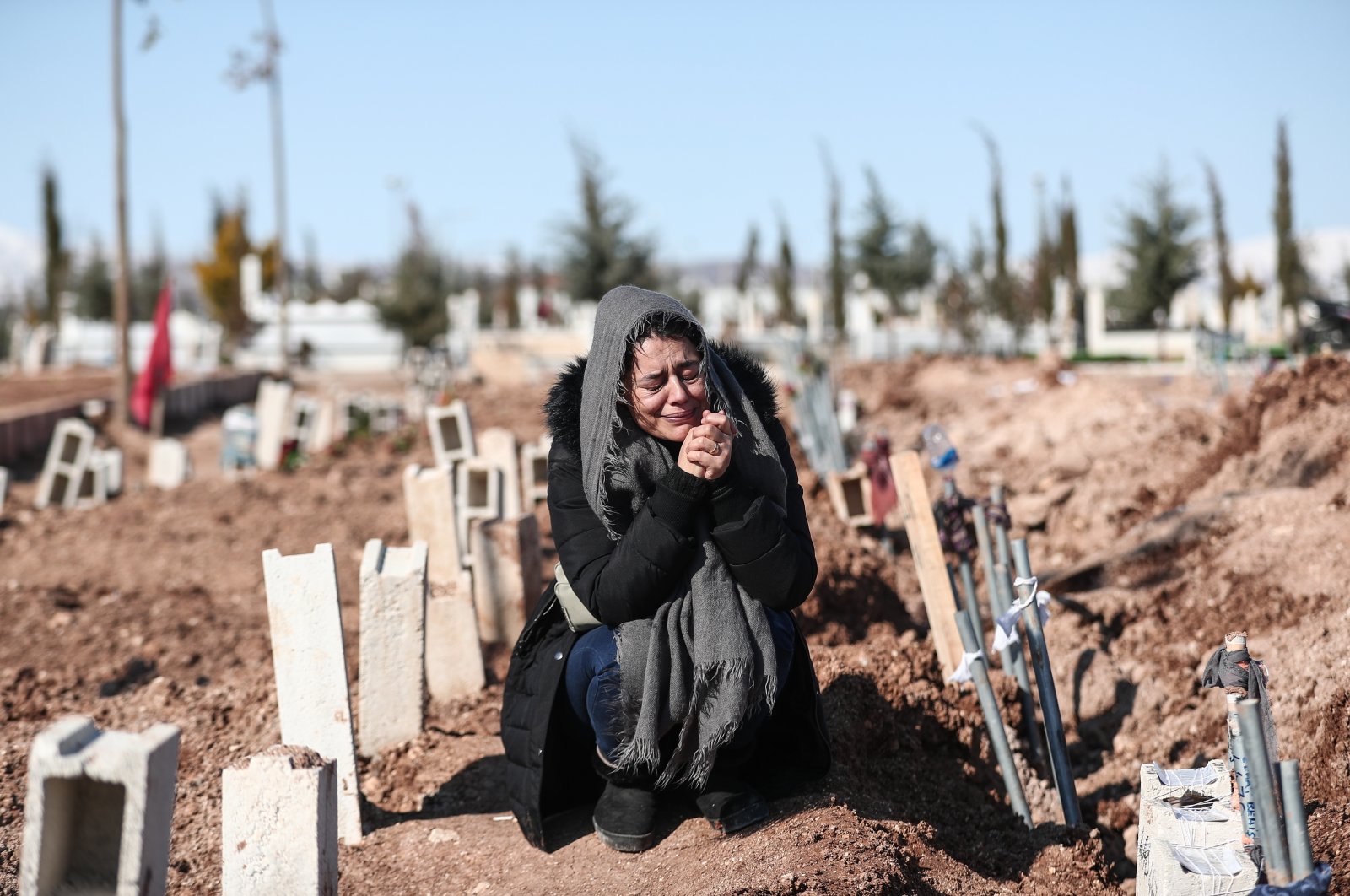 A woman mourns her relatives at a mass grave area following a major earthquake in Adıyaman, southeastern Türkiye, Feb. 11, 2023. (EPA Photo)
