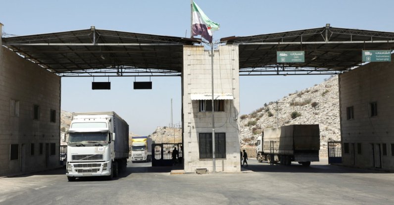 Trucks drive past the Bab al-Hawa crossing at the Turkish-Syrian border, in Idlib governorate, Syria, June 30, 2021. (Reuters Photo)