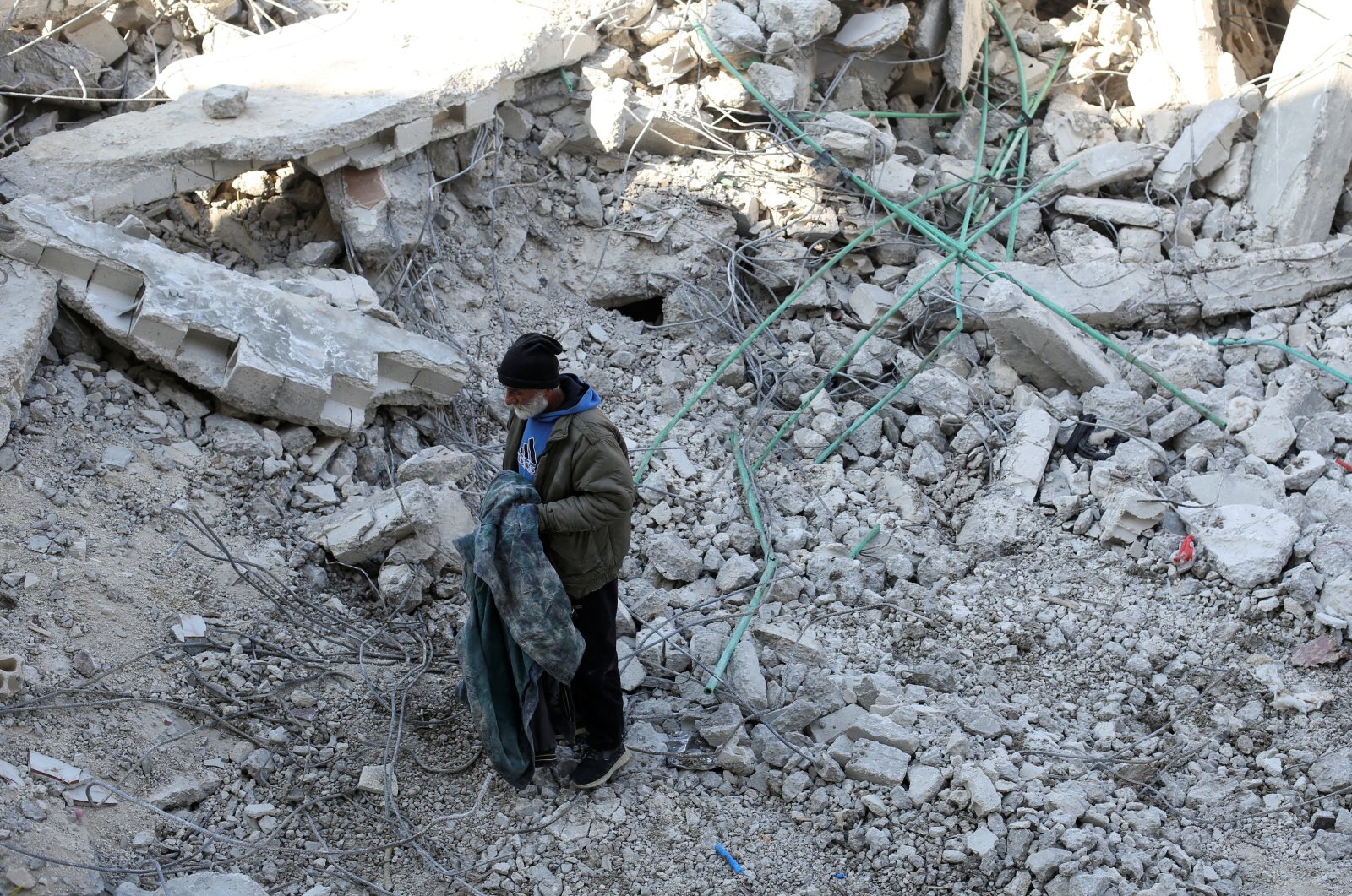 Syrian father Nader Fadil, who lost his wife and two children in the earthquake, stands on the rubble of his damaged home, Jableh, Syria, Feb. 12, 2023. (Reuters Photo)
