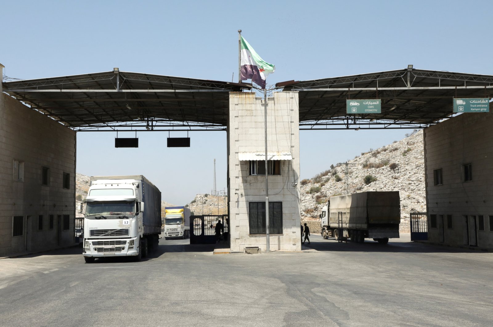 Trucks drive past the Bab al-Hawa crossing at the Turkish-Syrian border, in Idlib governorate, Syria, June 30, 2021. (Reuters Photo)