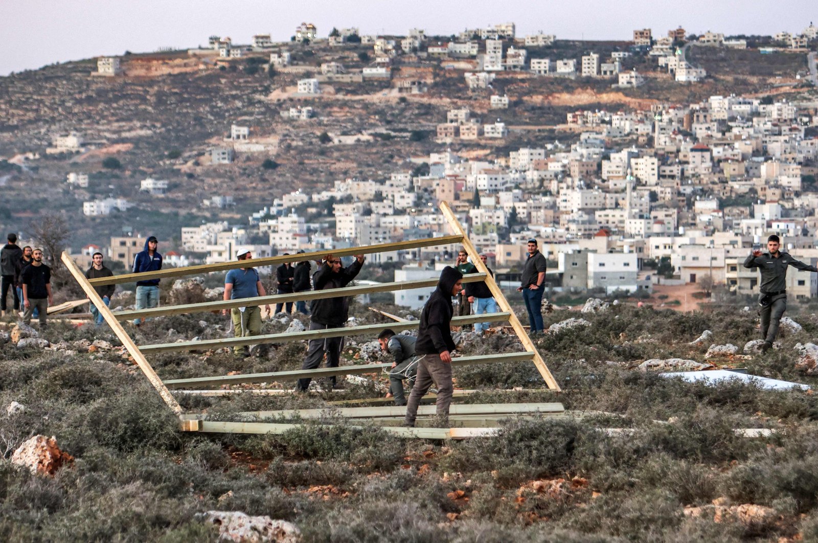 Israeli border guards remove a structure erected by settlers attempting to reestablish an illegal settlement outpost called Or Haim, near the settlement of Migdalim, in the north of occupied West Bank on Jan. 22, 2023. (AFP Photo)
