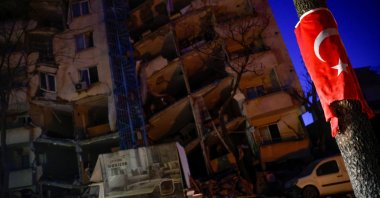 A Turkish flag is seen on a pole in front of a collapsed building, as rescues continue in the aftermath of a deadly earthquake in Kahramanmaraş, Türkiye, Feb. 12, 2023. (Reuters Photo)
