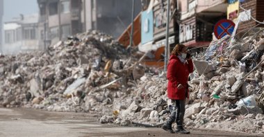 A woman stands near rubble that used to be her home, following the deadly earthquake in Iskenderun, Türkiye, Feb. 12, 2023. (Reuters Photo)