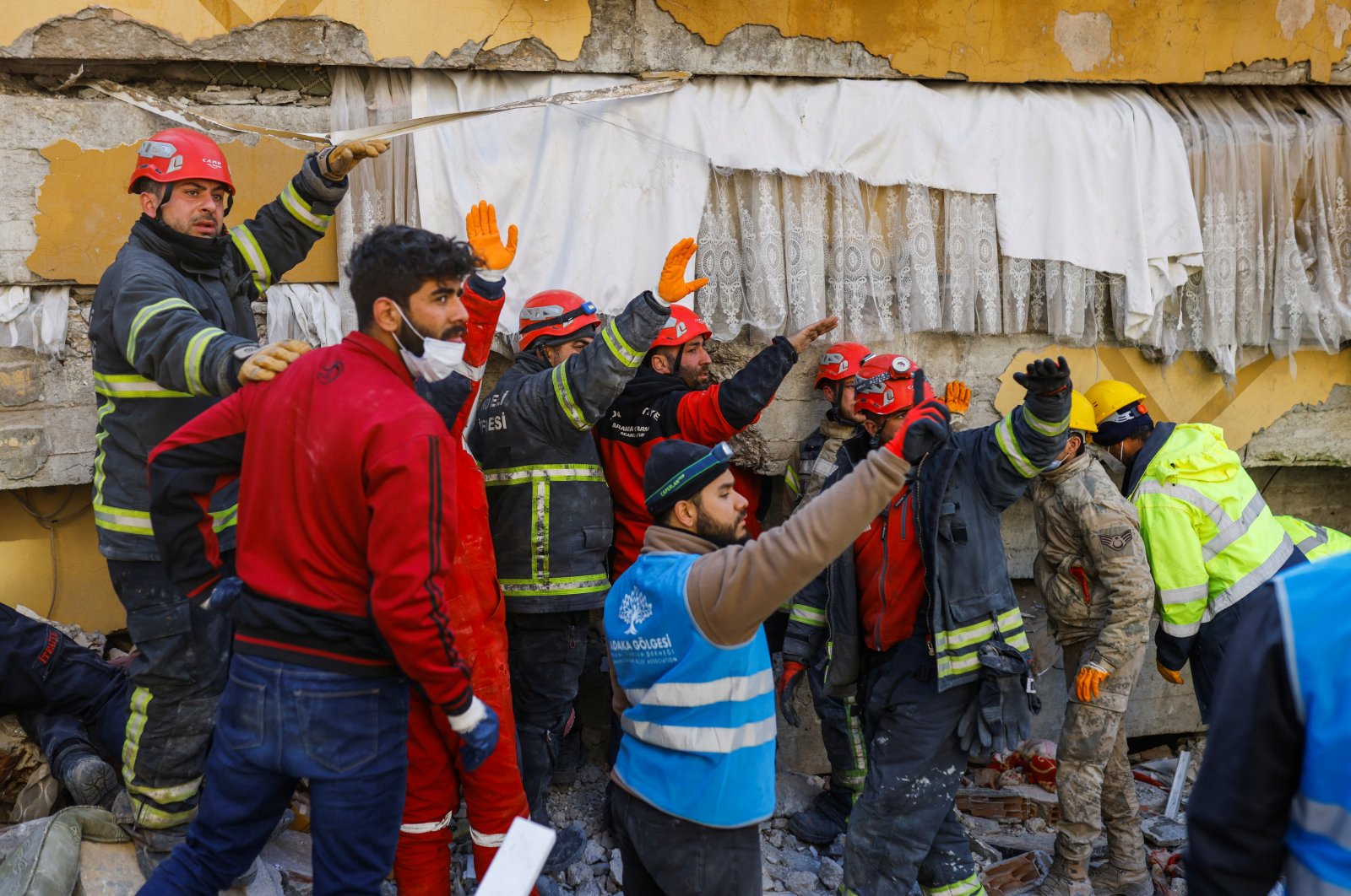 Rescuers gesture as they work to rescue 11-year-old survivor Mohammad Alkanaas in the aftermath of a deadly earthquake, Hatay, Türkiye, Feb. 11, 2023. (Reuters Photo)