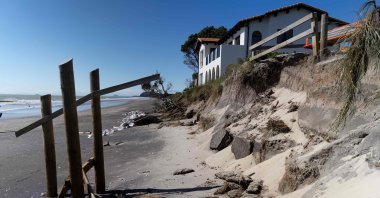 This picture shows a coastal home after part of its back garden and sand was washed away during the storm surge caused by Cyclone Gabrielle, Waihi Beach in the Bay of Plenty, New Zealand, Feb. 15, 2023. (AFP Photo)