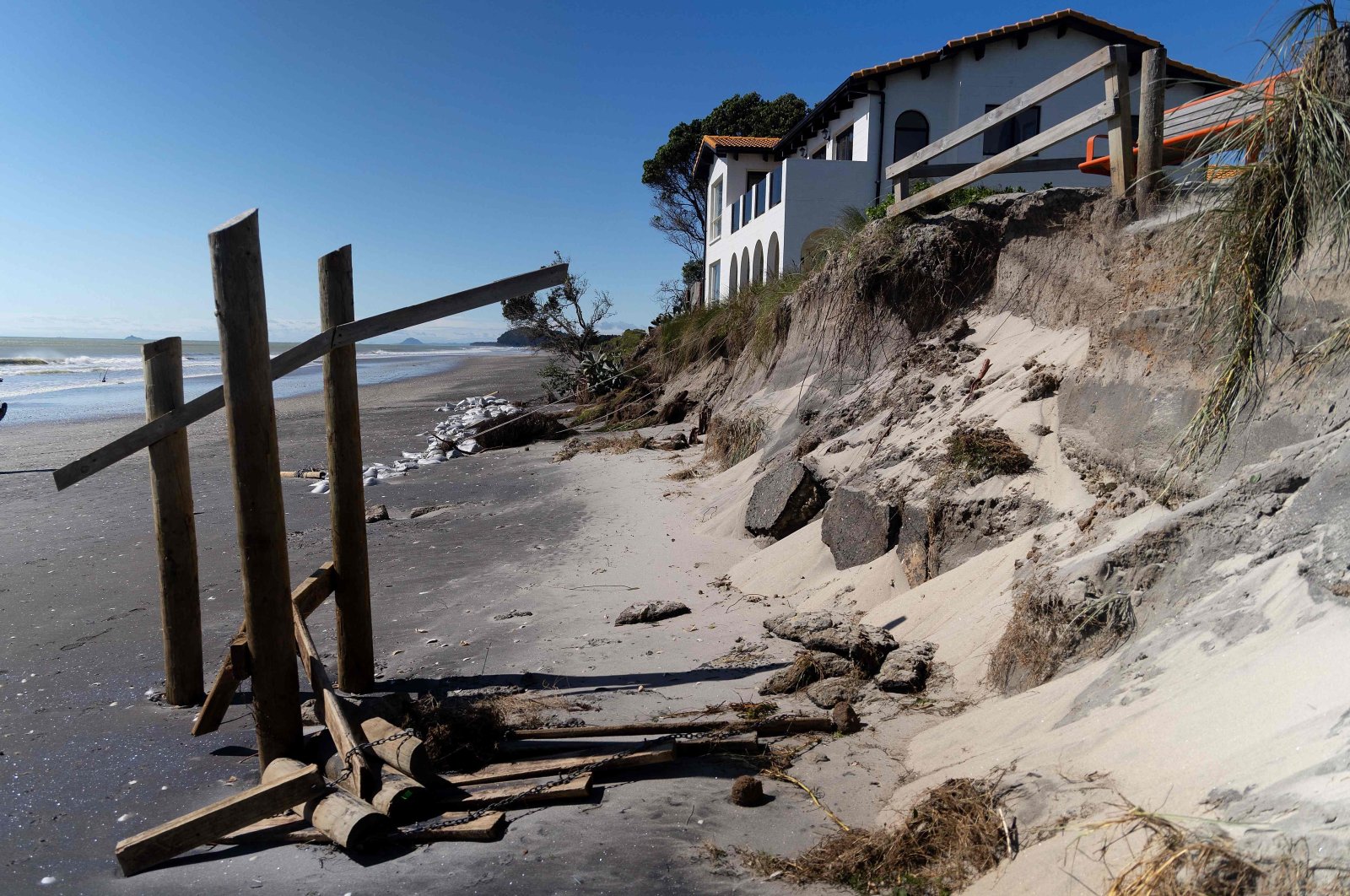 This picture shows a coastal home after part of its back garden and sand was washed away during the storm surge caused by Cyclone Gabrielle, Waihi Beach in the Bay of Plenty, New Zealand, Feb. 15, 2023. (AFP Photo)