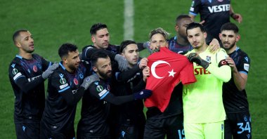 Trabzonspor players hold a Türkiye T-shirt to commemorate victims of last week&#039;s earthquakes after their team&#039;s goal against Basel in the first leg of the UEFA Europa Conference League knockout playoffs at Şenol Güneş Sports Complex Akyazı Stadium, in Trabzon, Türkiye, Feb. 16, 2023. (AA Photo)