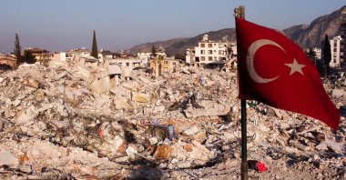 This aerial photograph shows a Turkish flag waving over the rubble of destroyed buildings in Antakya, a week after a deadly earthquake struck parts of Türkiye and Syria, Hatay, Türkiye, Feb. 14, 2023. (AFP Photo)