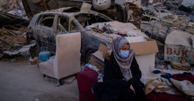A woman waits for a relative near the rubble of collapsed buildings in Hatay, southern Türkiye, Feb. 14, 2023. (AFP Photo)
