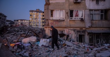 A man walks on debris of collapsed buildings after the powerful Feb. 6 earthquake in Hatay, Türkiye, Feb. 15, 2023. (EPA Photo)