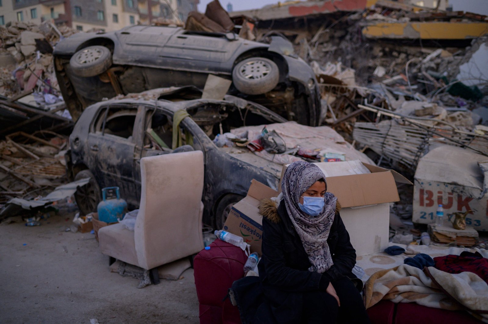 A woman waits for a relative near the rubble of collapsed buildings in Hatay, southern Türkiye, Feb. 14, 2023. (AFP Photo)