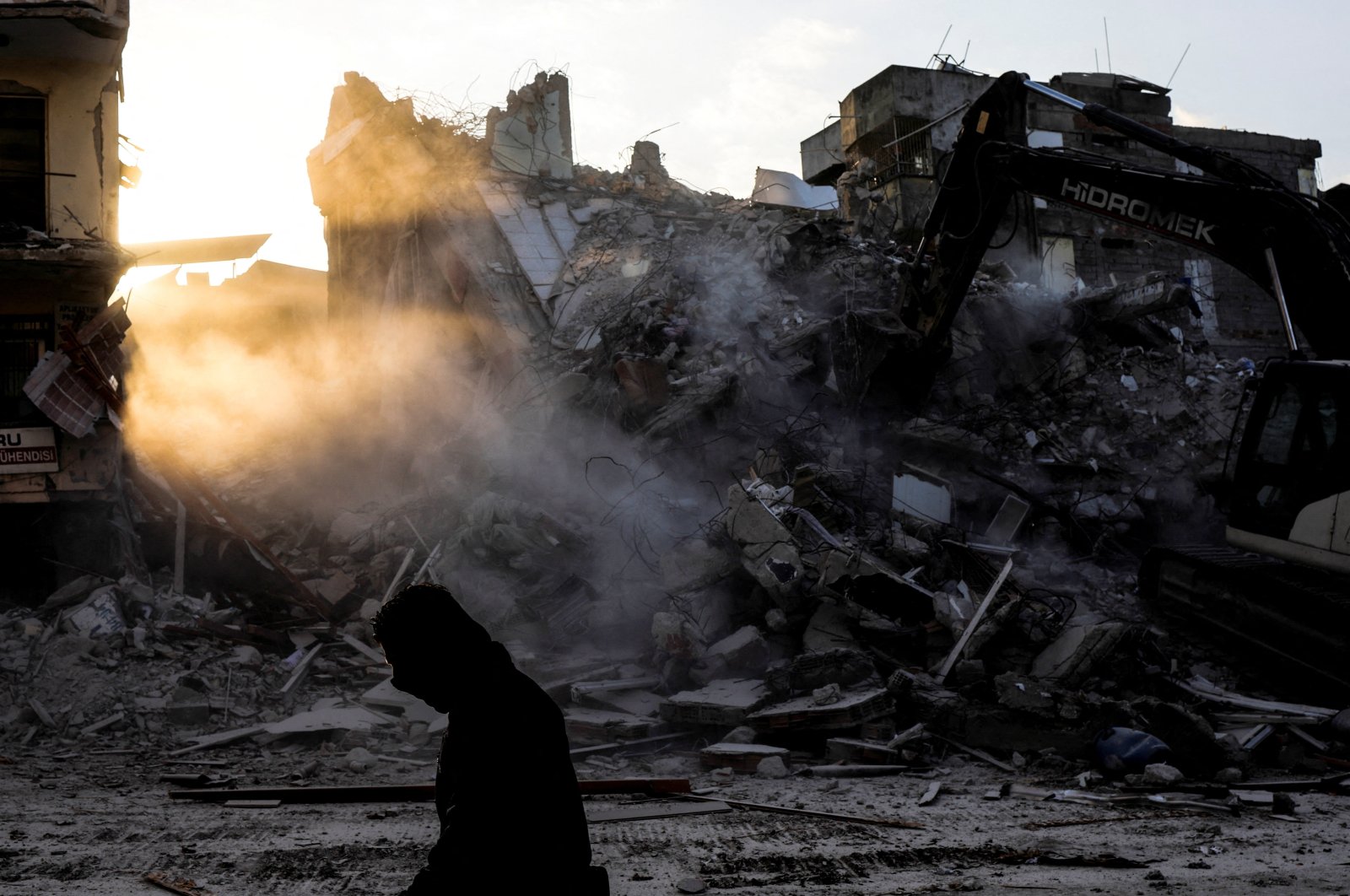 A man walks next to a bulldozer in the aftermath of a deadly earthquake, in Antakya, southeastern Türkiye, Feb. 16, 2023. (Reuters Photo)