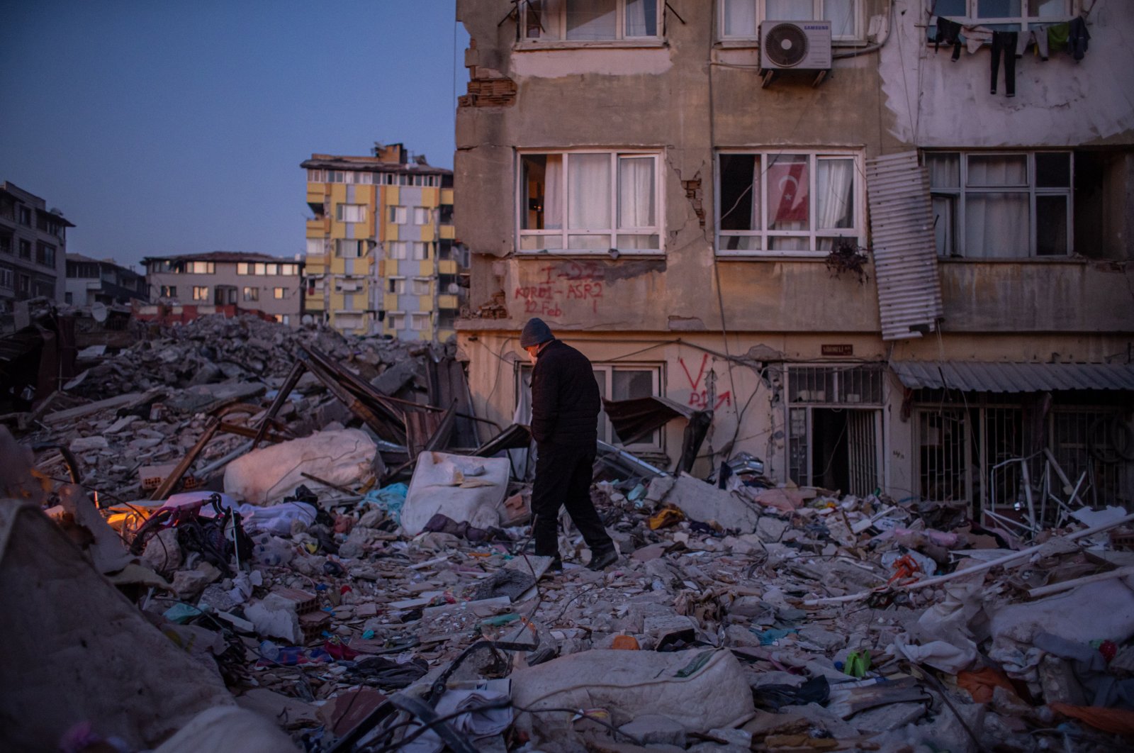 A man walks on debris of collapsed buildings after the powerful Feb. 6 earthquake in Hatay, Türkiye, Feb. 15, 2023. (EPA Photo)