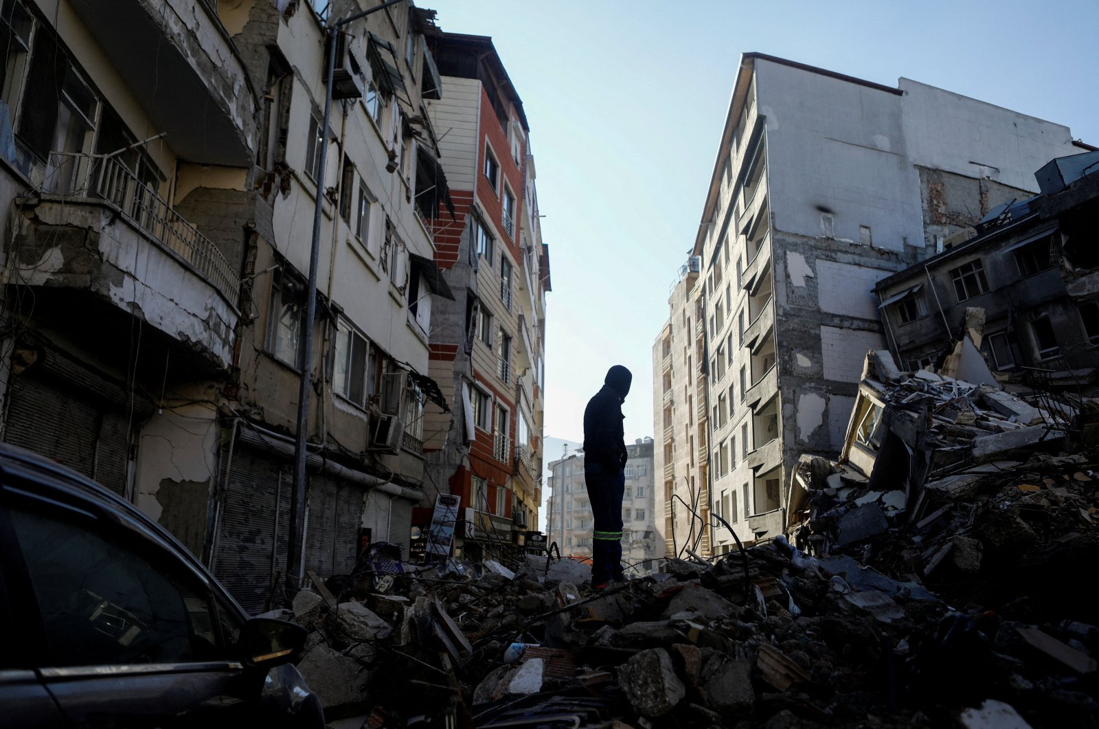 A man stands on rubble, in the aftermath of the deadly earthquake, in Hatay, Türkiye Feb. 17, 2023. (Reuters Photo)