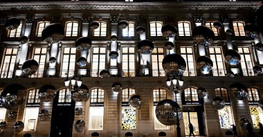 A pedestrian walks past a display of convex mirrors adorning the exterior of the Louis Vuitton flagship building off Place Vendome in Paris, France, Jan. 26, 2023. (AFP Photo)