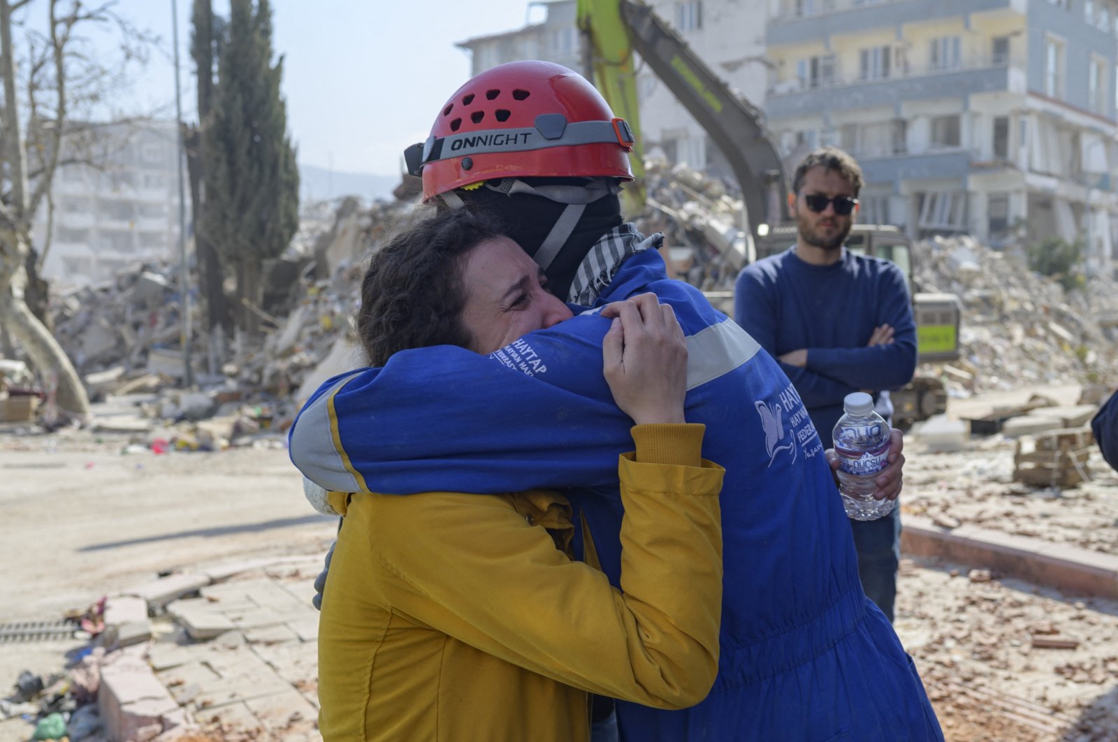 Mehmet Toğoğlu, the head of the search and rescue team of the local NGO Haytap, hugs a woman in tears after he failed to rescue her two cats in Antakya, Türkiye, Feb. 18, 2023. (AFP Photo)