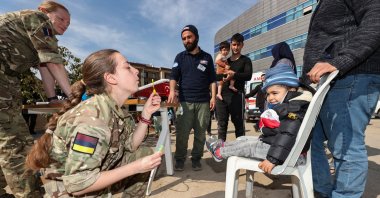 A nurse blows a bubble for a child after checking his condition at a field hospital in the earthquake-stricken Kahramanmaraş province, Türkiye, Feb. 19, 2023. (AA Photo)