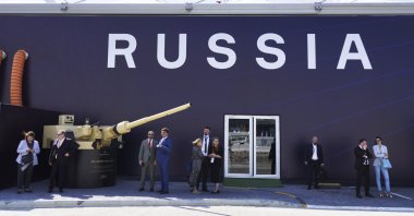 Russian salespeople stand by a tent for Russian weapons manufacturers at the International Defense Exhibition and Conference in Abu Dhabi, United Arab Emirates, Monday, Feb. 20, 2023. (AP Photo)