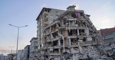 A man looks up at a collapsed building in Hatay, southern Türkiye, Feb. 19, 2023. (AFP Photo)