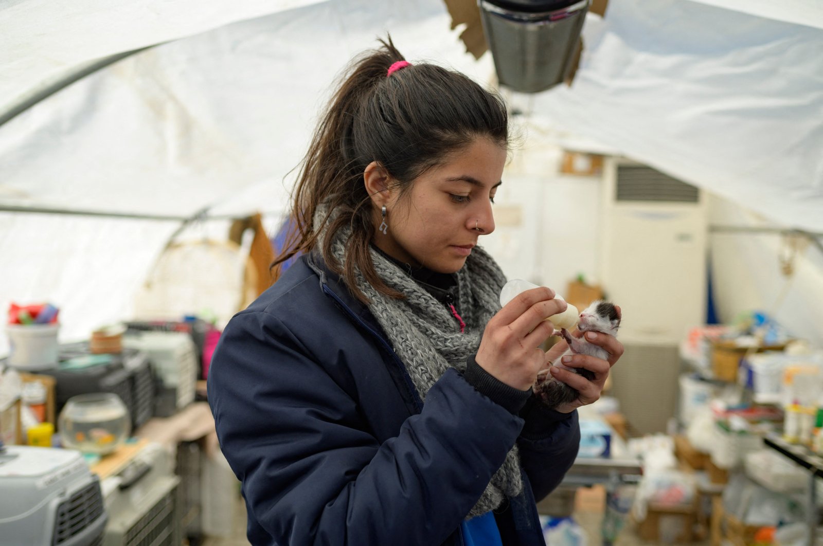 Petek Nur Sezer, a volunteer for the local NGO Haytap, feeds a kitten in Antakya, south of Türkiye, Feb. 18, 2023. (AFP Photo)