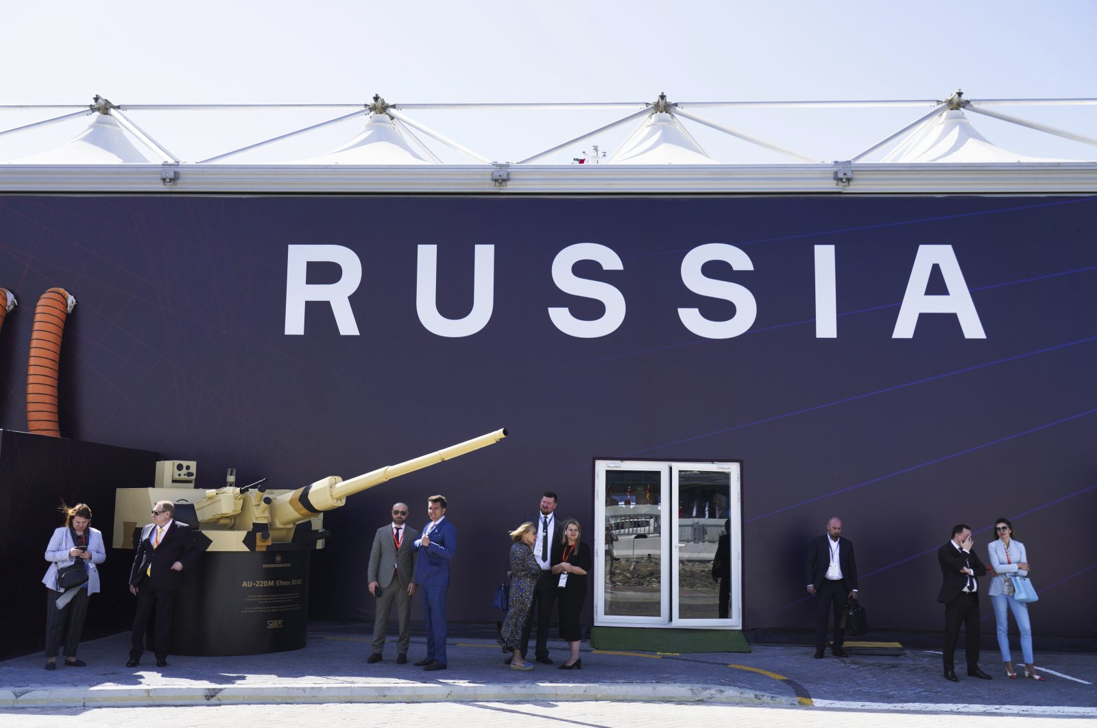 Russian salespeople stand by a tent for Russian weapons manufacturers at the International Defense Exhibition and Conference in Abu Dhabi, United Arab Emirates, Monday, Feb. 20, 2023. (AP Photo)