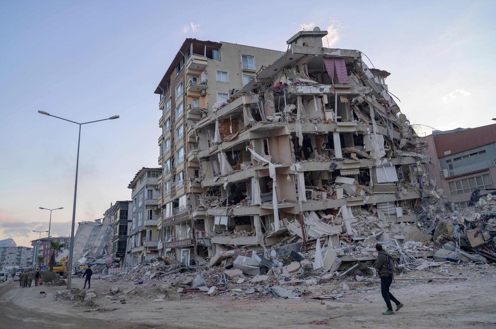 A man looks up at a collapsed building in Hatay, southern Türkiye, Feb. 19, 2023. (AFP Photo)