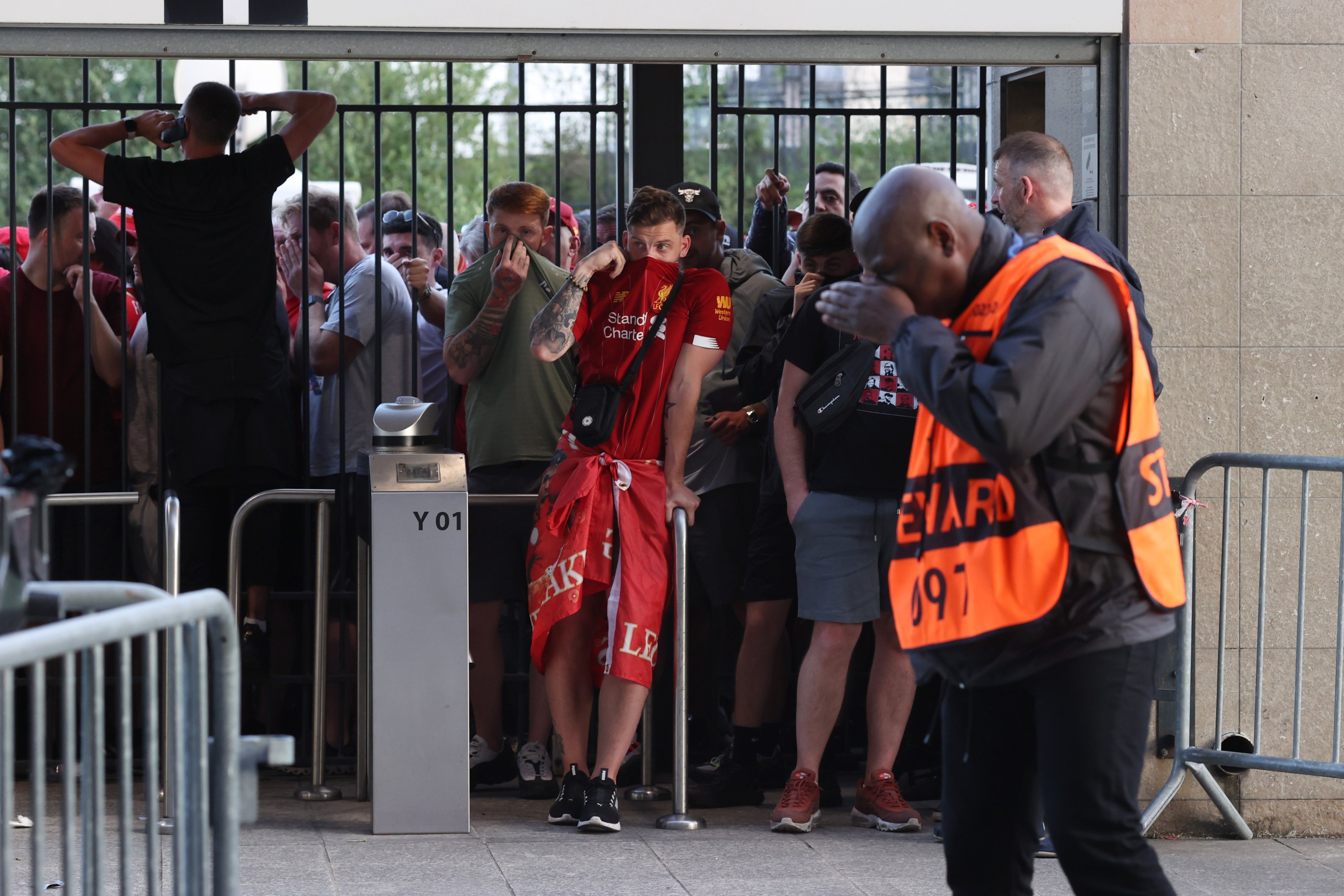 Pendukung Liverpool merasakan efek gas air mata melihat melalui gerbang yang tertutup sebelum pertandingan final Liga Champions UEFA antara melawan Real Madrid di Stade de France, Paris, Prancis, 28 Mei 2022. (Foto Getty Images)