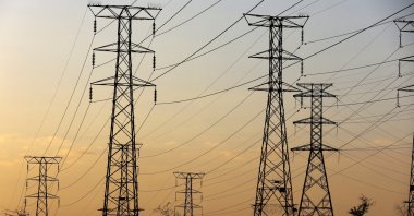 A man walks beneath electricity pylons during frequent power outages from South African utility Eskom, caused by its aging coal-fired plants, in Orlando, Soweto, South Africa, Jan. 16, 2023. (Reuters Photo)