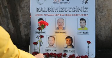 A person places a flower in front of a picture of tourist guides who lost their lives in recent quakes, Ankara, Türkiye, Feb. 21, 2023. (AA Photo)