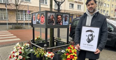 Hayrettin Saraçoğlu holds a picture of his brother Fatih Saraçoğlu, who was among the killed during the racist attack in Hanau, Germany in 2020, during a commemoration ceremony on the scene of the incident in Hanau, Feb. 19, 2023. (AA Photo)