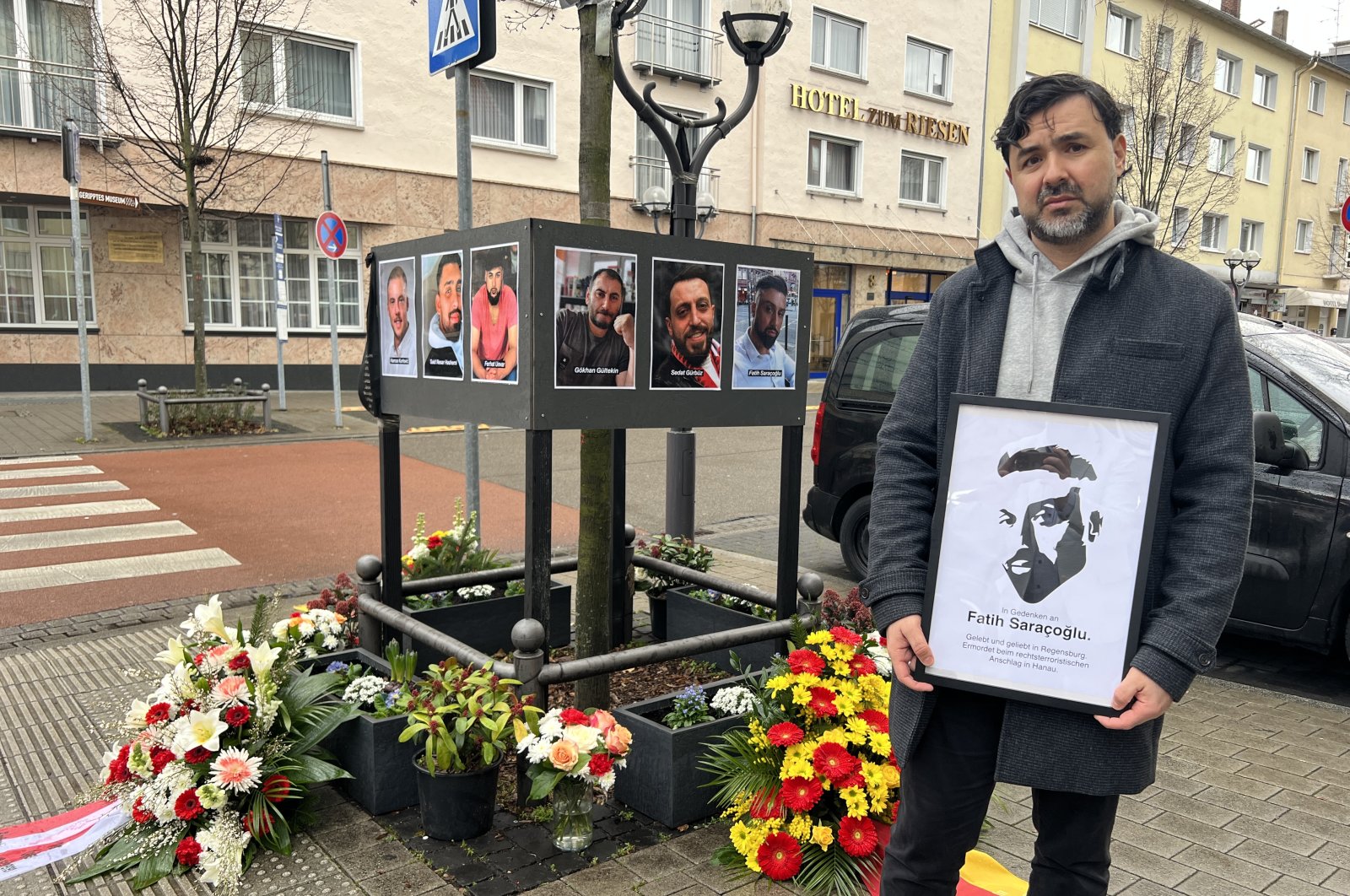 Hayrettin Saraçoğlu holds a picture of his brother Fatih Saraçoğlu, who was among the killed during the racist attack in Hanau, Germany in 2020, during a commemoration ceremony on the scene of the incident in Hanau, Feb. 19, 2023. (AA Photo)