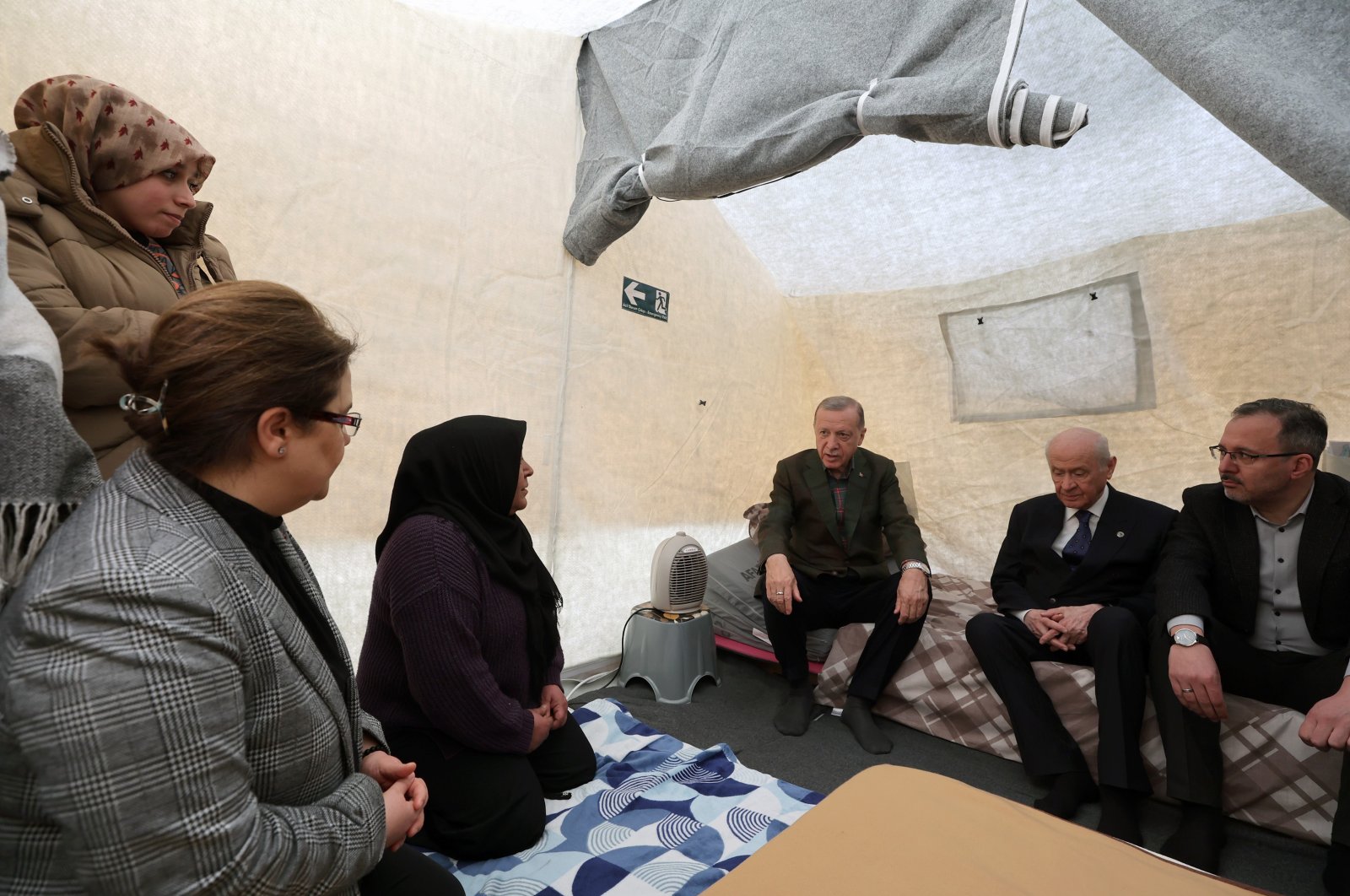 President Recep Tayyip Erdoğan (C) talks to a survivor in a tent in earthquake-hit Osmaniye, southern Türkiye, Feb. 21, 2023. (IHA Photo)