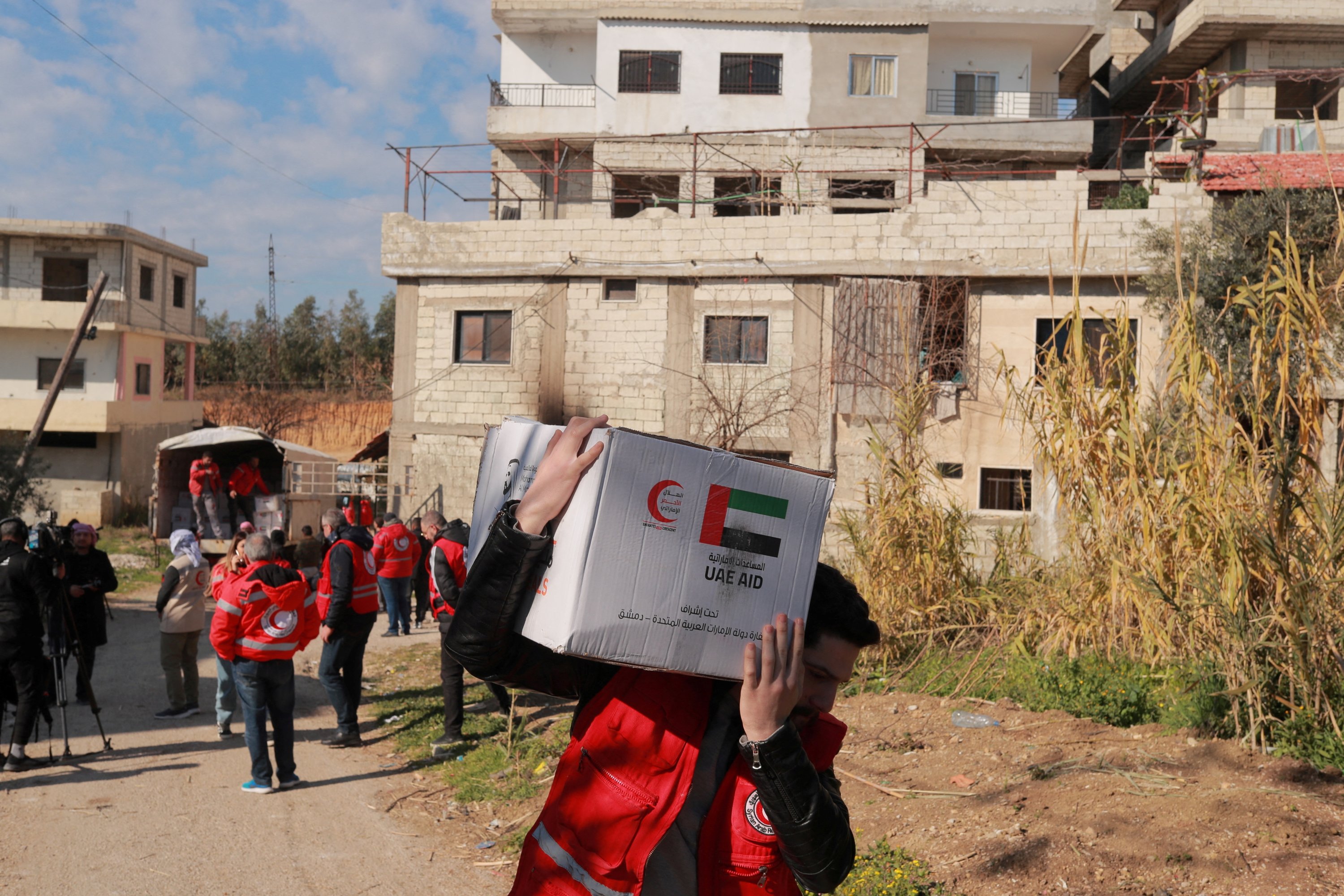 Seorang rekan Bulan Sabit Merah Arab Suriah membawa kotak bantuan kemanusiaan yang ditawarkan oleh Bulan Sabit Merah Emirates sebagai tanggapan atas gempa mematikan di Jableh, Suriah, 17 Februari 2023. REUTERS/Amr Alfiky