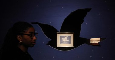 A gallery employee looks on alongside "Souvenir de voyage" painting by Belgian artist Rene Magritte at Christie&#039;s auction house during the press preview ahead of "The Art of the Surreal evening sale"  London, U.K., Feb. 21, 2023. (AFP Photo)