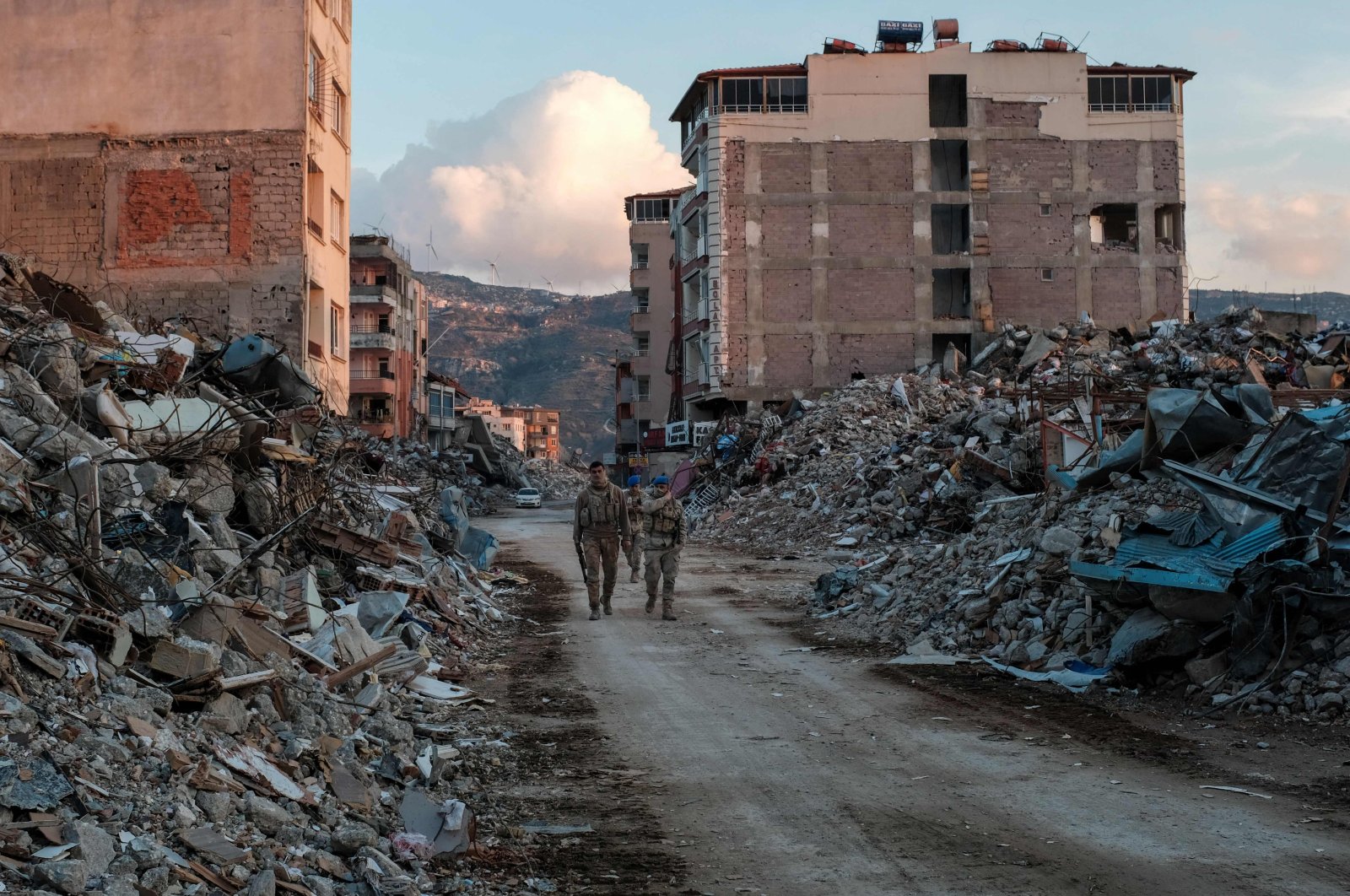 Turkish Armed Forces members walk among collapsed buildings, a day after a 6.4 magnitude earthquake struck the region, in the coastal city of Samandağ, Türkiye, Feb. 21, 2023. (AFP Photo)