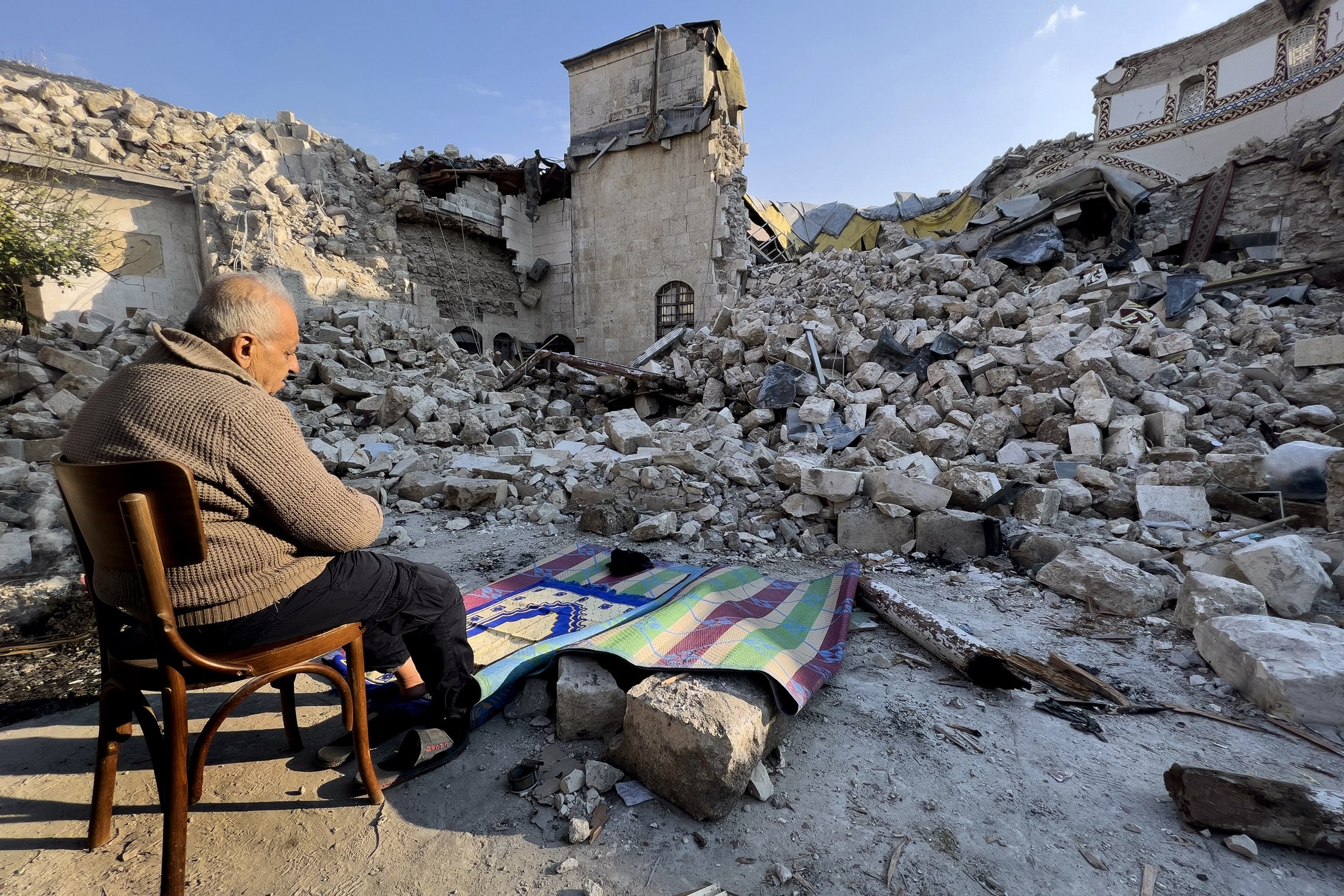 Türk vatandaşı Mehmet İsmet, 11 Şubat 2023, Türkiye'nin Antakya kentindeki büyük depremde yıkılan tarihi Habib Najjar camisinin enkazı önünde dua ediyor. (AP Fotoğrafı)