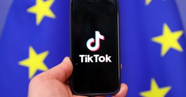 A logo of TikTok app is seen on a screen of a mobile phone with a European Union flag in the background. (AA Photo)