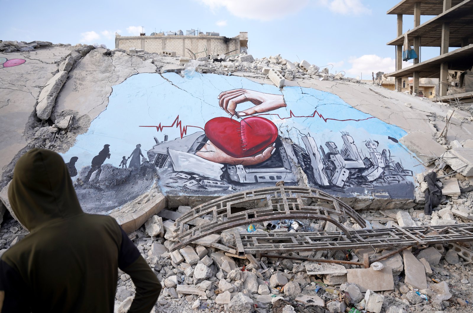 Syrian artists, who met in the town of quake-ravaged Jindires, painted the suffering of the people on the wall of a destroyed building, Afrin, Syria, Feb. 22. 2023. (AA Photo)