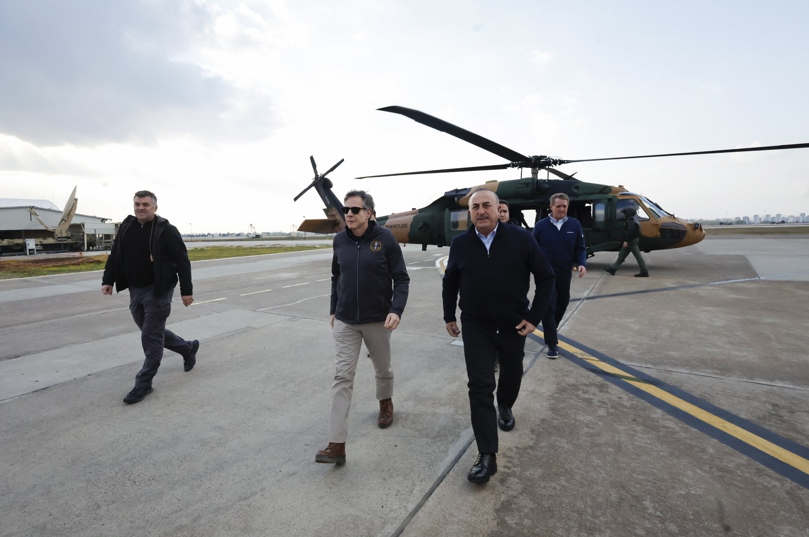 Foreign Minister Mevlüt Çavuşoğlu (Center-R) and U.S. Secretary of State Antony Blinken (2nd-L) disembark a helicopter, following a tour of the earthquake-stricken areas of Hatay, at Incirlik Air Base near Adana, Türkiye, Feb. 19, 2023. (AP Photo)